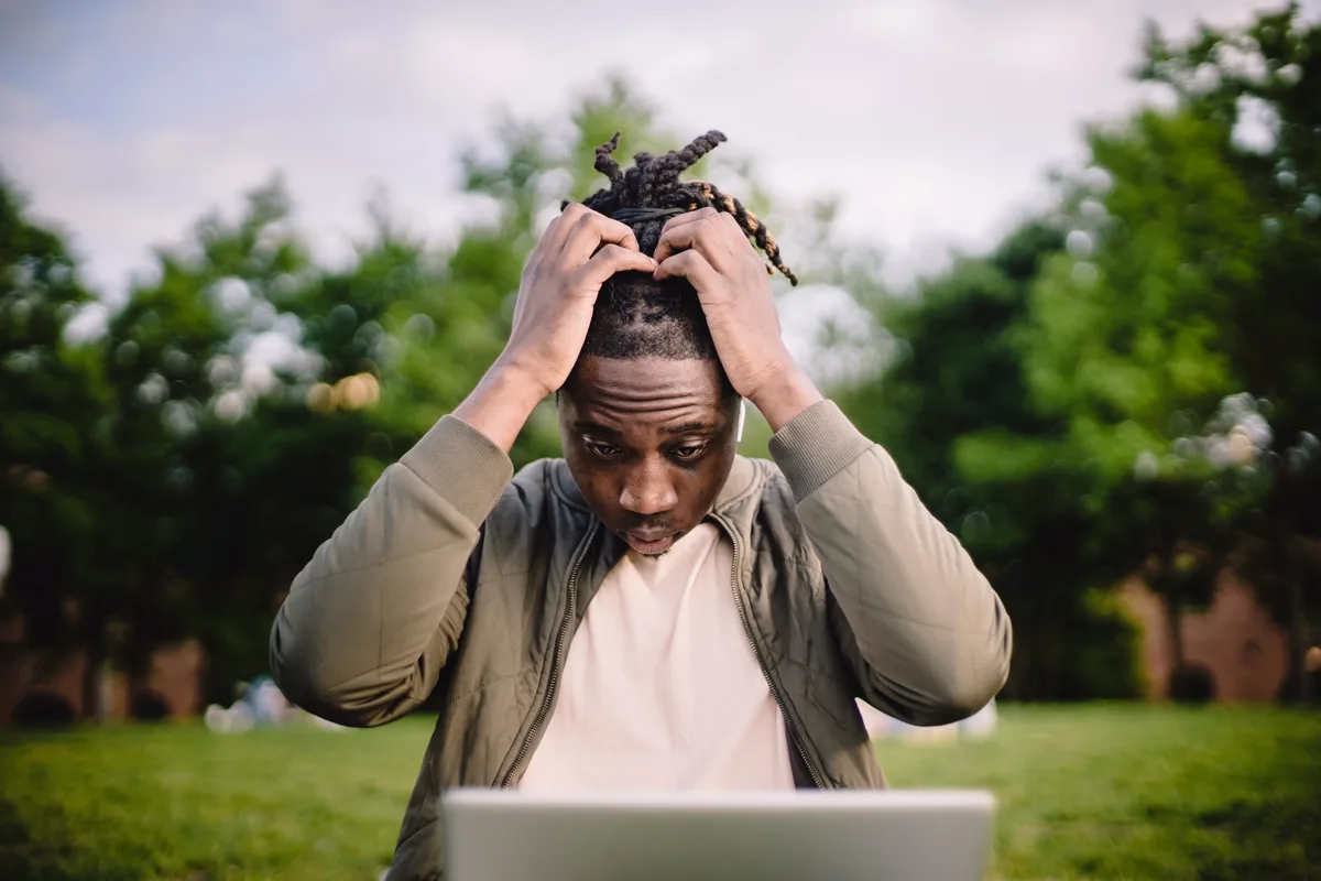 A South African reviewing bank statements and credit accounts at a laptop