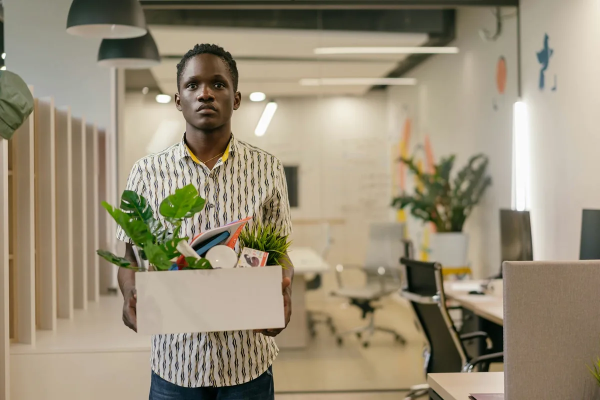 Retrenched professional carrying personal belongings after losing job